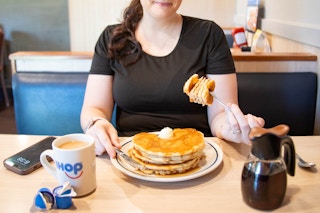 a person eating pancakes at ihop