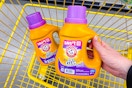 hand lifting an arm & hammer laundry detergent above a cart
