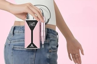 Woman holding a cordless nail file machine.