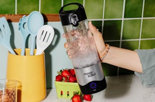 someone holding a magic bullet blender