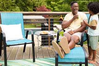 a dad and son on their back patio by a furniture set
