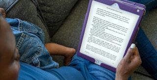 person sitting on couch reading ebook on ipad