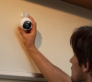 A man installing an outdoor Eufy camera.