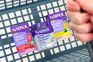 hand holding basket with natrol sleep supplements
