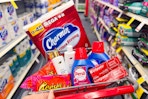 charmin toilet paper, colgate toothpaste, persil detergent, dove shampoo, and reeses candy in a cart
