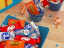 a bowl and cup full of fun-sized candy on a table 