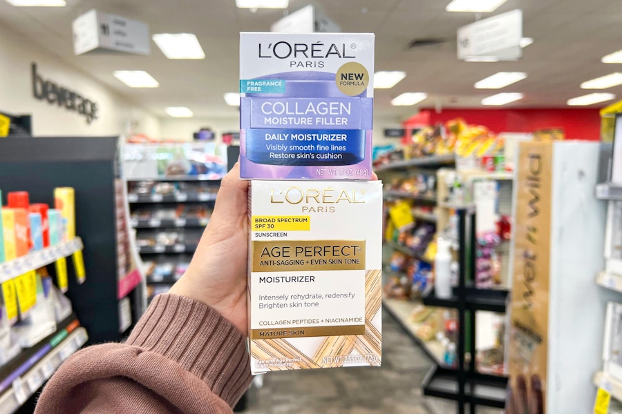 person holding 2 loreal moisturizers