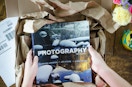 A person putting a photography book into the