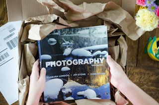 A person putting a photography book into the