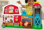 child playing with a Fisher Price farm playset