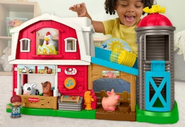 child playing with a Fisher Price farm playset
