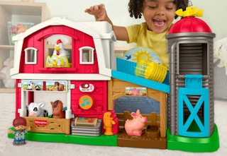 child playing with a Fisher Price farm playset