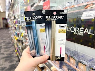 hand holding two loreal telescopic mascaras