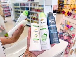 hand holding three dove deodorants in walgreens