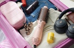 a pink hair dryer bush in a suitcase