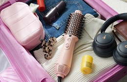 a pink hair dryer bush in a suitcase
