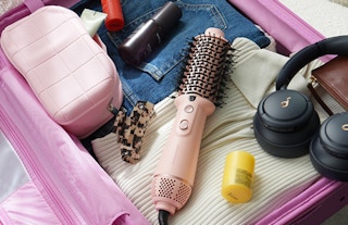 a pink hair dryer bush in a suitcase