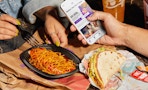 people eating taco bell enchirito and double decker taco with app on phone