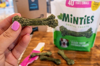 hand holding treats with Minities bag and prime box in background