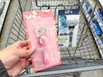 hand holding venus razor and gillette razor in cart
