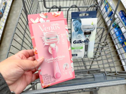 hand holding venus razor and gillette razor in cart