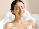 a person in a bathtub with a bath pillow