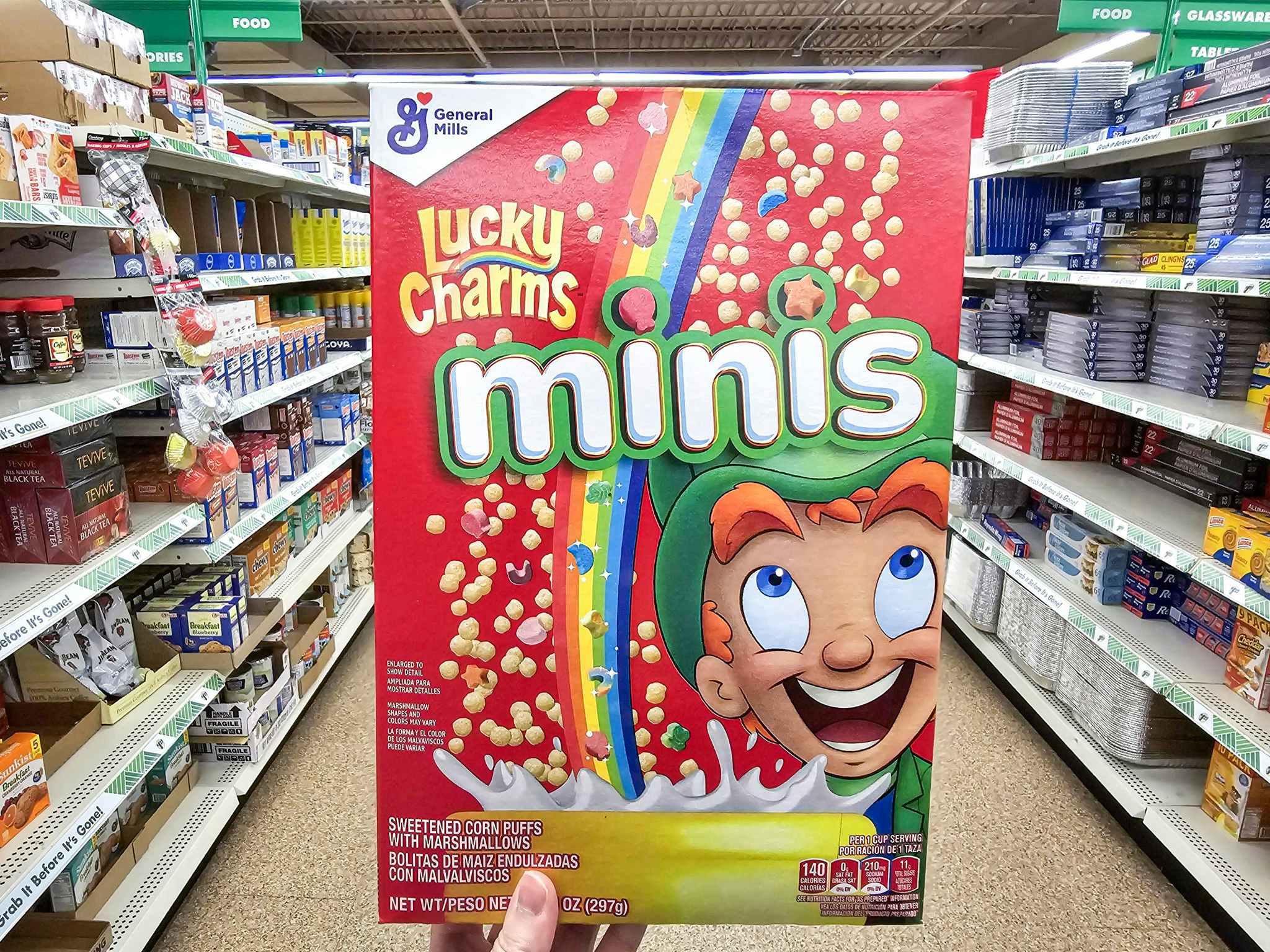 person holding a box of lucky charms minis cereal