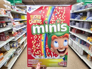person holding a box of lucky charms minis cereal
