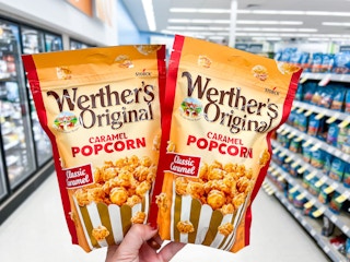 hand holding two bags of werthers popcorn