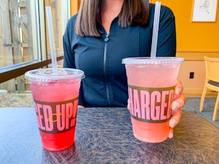a person holding a charged lemonade at panera