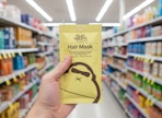 person holding a sun bum hair mask in an aisle