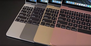 A close up on 4 different colored Macbooks' keyboards