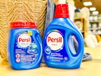 persil detergent on store shelf in front of basket and towel