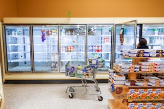 An empty dairy case at a grocery store, showing a milk shortage.