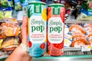 hand holding two simply pop prebiotic sodas at publix