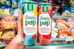 hand holding two simply pop prebiotic sodas at publix