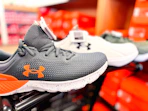 under armour sneakers on the edge of a shopping cart in the shoe aisle