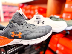 under armour sneakers on the edge of a shopping cart in the shoe aisle