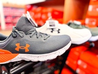 under armour sneakers on the edge of a shopping cart in the shoe aisle