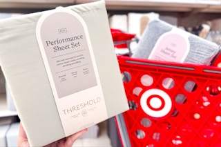 hand holding threshold sheet sets in front of a target cart