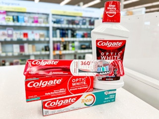two toothpastes, a toothbrush, and mouthwash on store beauty counter