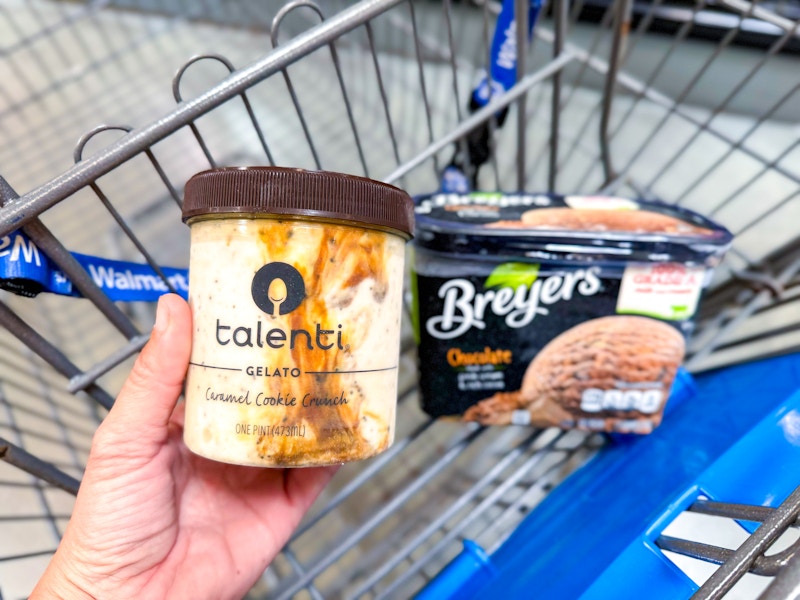 hand holding talenti gelato over walmart cart with breyers ice cream