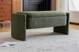 lifestyle image of the dark green boucle storage ottoman in home setting