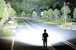 a person holding a flashlight in the street