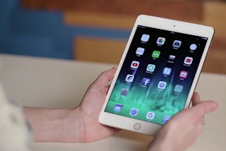 person holding a white ipad mini