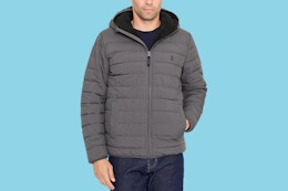 Close up shot of a male model wearing an Izod puffer jacket in the color grey