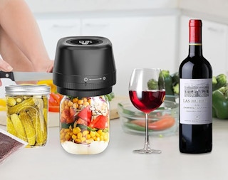 a mason jar vacuum sealer on a jar next to a jar of pickles and wine 