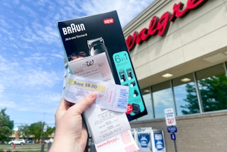 hand holding a braun 6-in-1 trimmer with a register reward and walgreens receipt outside of a walgreens store