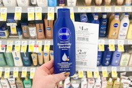 person holding a bottle of nivea lotion with coupons