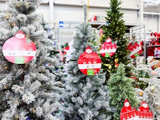 In-store photo taken of Walmart's Christmas tree area featuring the Holiday Time flocked 6-ft tree